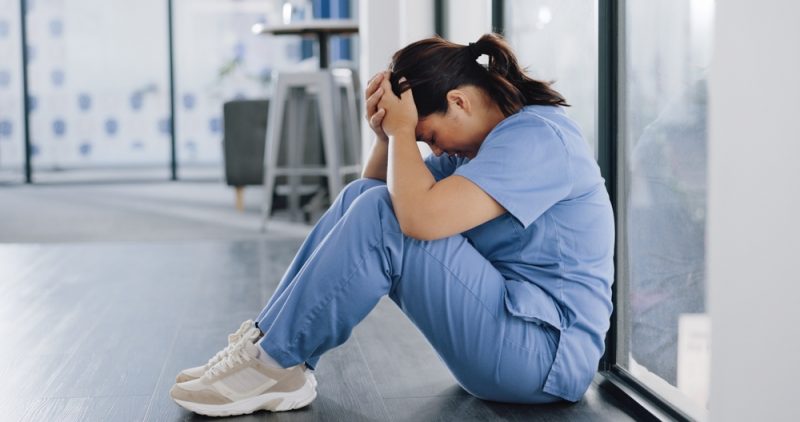 Erschöpfte Pflegekraft nach einer belastenden Schicht im Gesundheitswesen